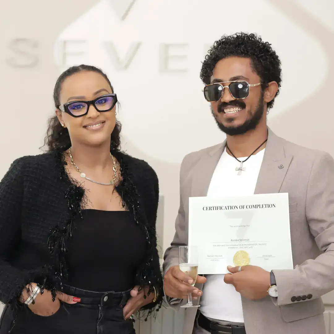 Permanent Makeup Certification at Seven Aesthetics: Teacher Betlehem Bereket with student Hiwotetsegay Mekonnen holding her certificate of completion after completing the course.