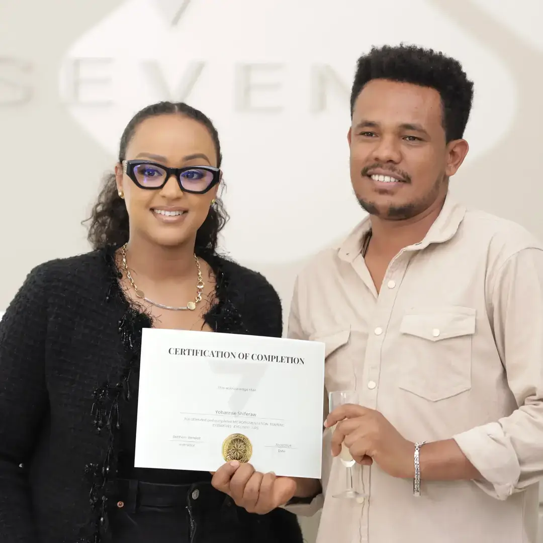 Permanent Makeup Certification at Seven Aesthetics: Teacher Betlehem Bereket with student Yodit Eshete holding her certificate of completion after completing the course.